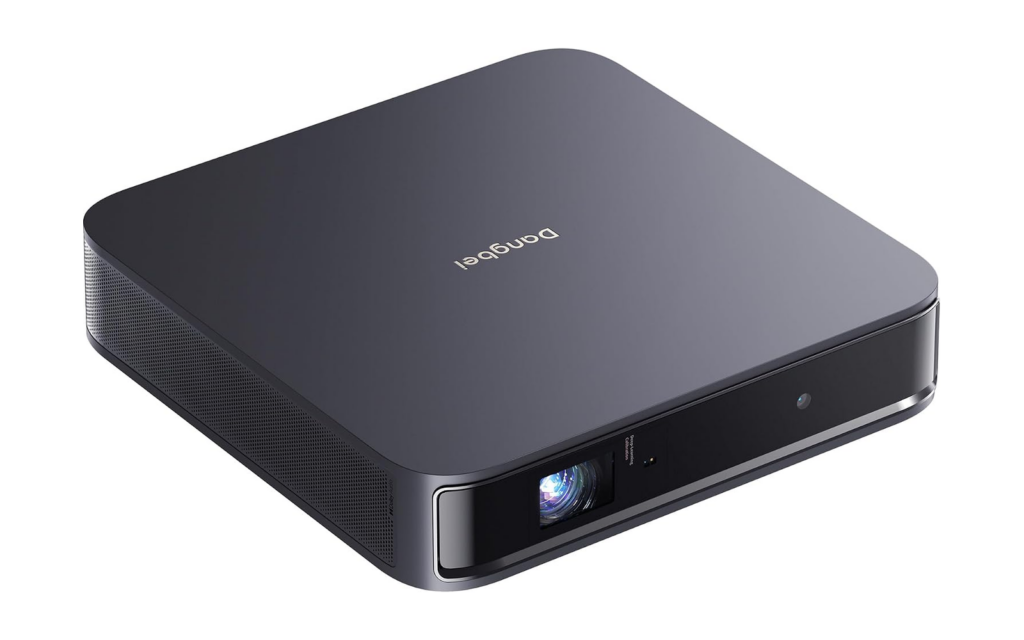 The Dangbei Atom laser projector, a flat dark gray square box with the Dangbei name on top and the lens at the front right corner.
